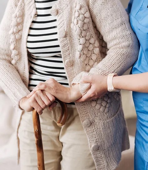 Caregiver holding elder's hand